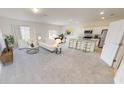 Open living room and kitchen with island and neutral colors at 1955 Hemingway Cir, Groveland, FL 34736