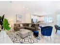 Spacious living room featuring sectional sofa and large TV at 8976 Amelia Downs Trl, Kissimmee, FL 34747