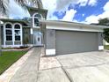 Two-story house with gray siding, white accents, and a paved walkway leading to the entrance at 14534 Potanow Trl, Orlando, FL 32837