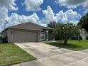 One-story house with a gray exterior and green lawn at 4260 Climbing Aster Ct, Saint Cloud, FL 34772