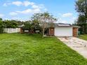 Brick house with a large front yard, driveway, and solar panels at 1005 Crescent Pkwy, Deland, FL 32724