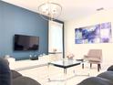 Modern living room with large TV, comfortable seating, and art at 791 Pebble Beach Dr, Davenport, FL 33896