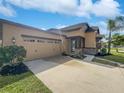 Tan house with stone accents, three car garage, and landscaped yard at 4701 Blackthorn Cir, Kissimmee, FL 34758