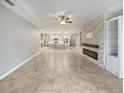 Open concept living room with a stone fireplace and kitchen access at 5408 Manchester Dr, St Cloud, FL 34771