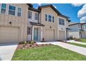 Tan townhome exterior with two-car garage and landscaping at 832 Longboat Dr, Davenport, FL 33896