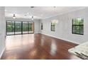 Spacious living room featuring hardwood floors, sliding glass doors and a chandelier at 450 Palermo Vista Ct, Longwood, FL 32750