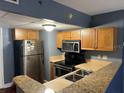 Galley kitchen with stainless steel appliances and granite countertops at 151 E Washington St # 322, Orlando, FL 32801