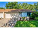 Tan and light blue house with attached garage and small front yard at 108 Clear Lake Cir, Sanford, FL 32773