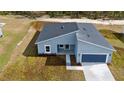 Aerial view of a new construction home with gray exterior and blue garage at 7883 Sw 138Th Street Rd, Ocala, FL 34473