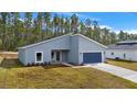 New construction home with gray exterior and blue garage door at 7883 Sw 138Th Street Rd, Ocala, FL 34473
