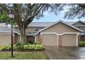 Two-story townhome with a two-car garage, landscaping, and a lamp post at 670 Post Oak Cir # 106, Altamonte Springs, FL 32701