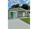 Exterior view of gray house with sliding glass doors and a paved patio at 117 N Observatory Dr, Orlando, FL 32835
