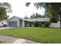 House exterior with gray siding, blue garage door and well maintained lawn at 1916 Bruce St, Kissimmee, FL 34741