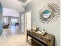 Bright and airy entryway with console table and sunburst mirror at 1471 Rolling Fairway Dr, Davenport, FL 33896