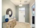 Bright entryway with a wooden console table and a decorative mirror at 1410 Wexford Way, Davenport, FL 33896