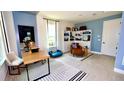 Stylish home office with built-in shelving and blue accent wall at 15131 Grove Lake Dr, Winter Garden, FL 34787