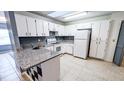 Bright kitchen features granite countertops and white cabinets at 4755 Sw 151St Pl, Ocala, FL 34473