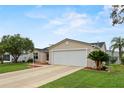 Tan one-story house with two-car garage and landscaping at 17394 Se 74Th Seabrook Ct, The Villages, FL 32162