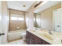 Bathroom with a tub, double vanity, and a large mirror at 13950 Morning Frost Dr, Orlando, FL 32828