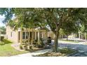 Tan two story house with lush landscaping and large tree in front at 13272 Roxboro Rd, Windermere, FL 34786