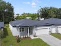 New single story house, gray exterior, two car garage, and landscaped yard at 2866 Lingo Ln, Orlando, FL 32822