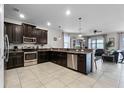 Open concept kitchen with dark cabinets and stainless steel appliances at 1427 Rolling Fairway Dr, Davenport, FL 33896