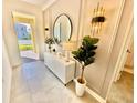 Bright entryway with a white console table, large mirror, and stylish light fixtures at 9095 Sommerset Hills Dr, Davenport, FL 33896