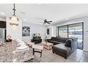Open living room with L-shaped sectional sofa, large TV, and sliding glass doors leading to the backyard at 8930 Sydney Ave, Kissimmee, FL 34747