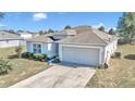 One-story house with a gray exterior, attached garage, and landscaping at 153 Juniper Run, Ocala, FL 34480