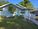 House exterior showcasing light blue siding and a landscaped front yard at 212 W Central Ave, Howey In The Hills, FL 34737