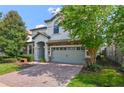 Two-story home with gray siding and brick driveway at 1435 Moon Valley Dr, Davenport, FL 33896