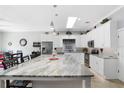 Modern kitchen featuring a large island with granite countertop and white cabinets at 900 Sussex Close, Orlando, FL 32804