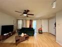 Living room with hardwood floors, green couch and access to patio at 2203 Yankee Pl # 427, Orlando, FL 32839