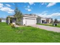 One-story house with gray garage door and landscaped lawn at 1833 Ross Hammock Ave, Groveland, FL 34736