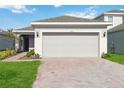 One-story house with gray garage door and landscaped lawn at 1833 Ross Hammock Ave, Groveland, FL 34736