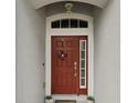 Red front door with sidelights and a decorative wreath at 3801 Tarsier Ct, Kissimmee, FL 34744