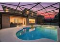 Inviting screened-in pool and patio area with outdoor kitchen at sunset at 290 Las Fuentes Dr, Kissimmee, FL 34746