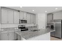 Modern kitchen with gray cabinets and granite countertops at 3150 Viceroy Ct, Poinciana, FL 34759
