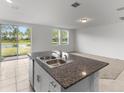 Kitchen with granite island, double sink, and view of backyard at 3206 Viceroy Ct, Poinciana, FL 34759