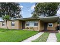 Tan single story home with carport and well-manicured lawn at 1916 Colton Dr, Orlando, FL 32822