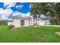 Charming pink house with a well-maintained lawn at 15639 Greater Groves Blvd, Clermont, FL 34714