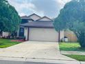 House exterior showcasing a two-car garage and driveway at 1011 Pegel Ct, Oviedo, FL 32765