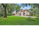 Two-story home with a tile roof, lush lawn, and mature trees at 732 Edgewater Dr, Orlando, FL 32804