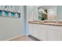 Double vanity bathroom with granite countertop, white cabinets, and tiled floor at 2928 Waterlily Way, Poinciana, FL 34759