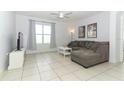 Spacious living room with L-shaped sofa, TV, and large window at 277 Ludisia Loop, Davenport, FL 33837