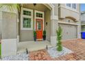 Front entrance with orange door and brick walkway at 2599 Nouveau Way, Kissimmee, FL 34741