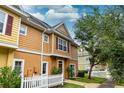 Townhouse exterior with charming details and a white picket fence at 2601 Gala S Rd # 107, Kissimmee, FL 34746