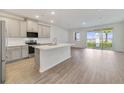 Open concept kitchen with gray cabinets, island, and stainless steel appliances at 707 Southern Edge Way, Sanford, FL 32771