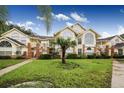 Two-story condo building with yellow exterior and palm trees at 5009 Laguna Bay Cir # 41, Kissimmee, FL 34746