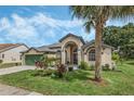 Tan one-story house with green garage door and landscaped yard at 16208 Magnolia Hill St, Clermont, FL 34714